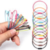 A hand holds a collection of 10 stainless steel wire keychain rings in various colors, arranged in a spiral.