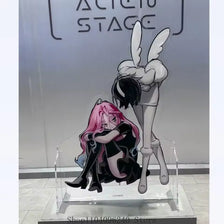 Acrylic figure of a female character with pink hair and black clothing displayed on a clear stand.