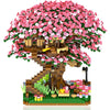 A miniature tree built from building blocks covered in pink and white flowers with a light feature.