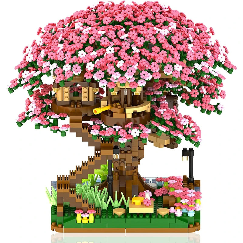 A miniature tree built from building blocks covered in pink and white flowers with a light feature.