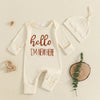 A cream ribbed long sleeve romper and matching knit hat for a baby boy