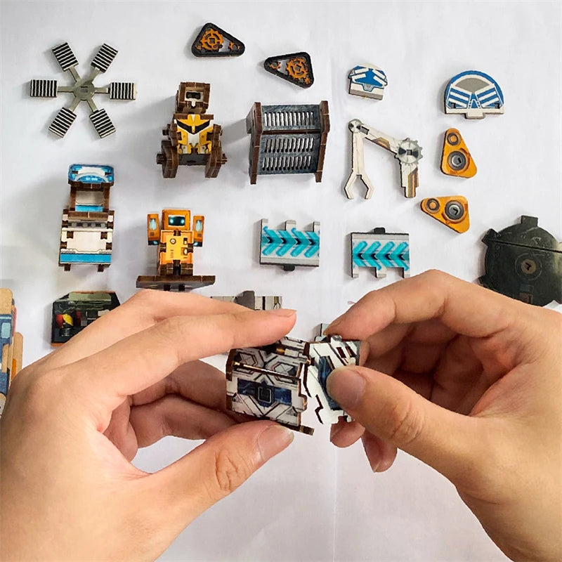 A hand holds a wooden miniature model kit puzzle bookend featuring planetary era scenes and an LED light.