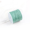 A roll of light green cotton nylon macrame cord for jewelry making and crafts.