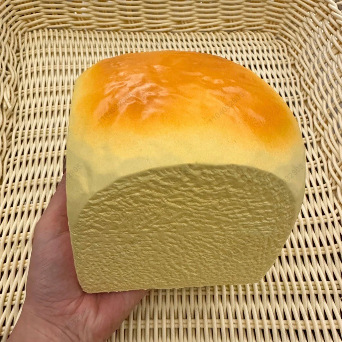 A yellow squishy toy shaped like a loaf of bread with an orange top resting in a woven basket.