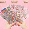 A hand holds a collection of colorful 3D landscape stickers featuring various scenes and objects.
