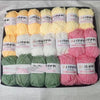 A pack of various colored yarn skeins including yellow, white, pink, and green wool for knitting and crochet projects.