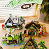 A set of miniature forest cabin building blocks featuring a house, greenhouse, and windmill.