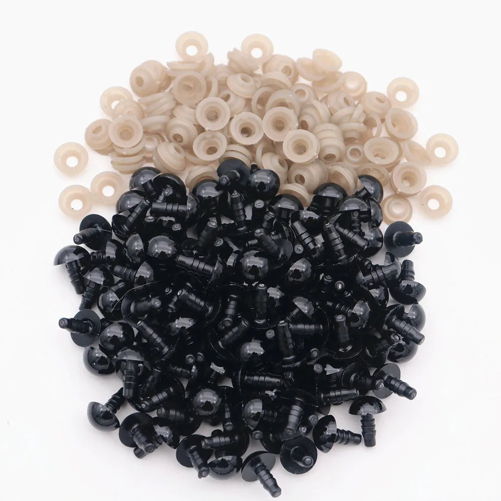 A pile of black plastic safety eyes with washers and a pile of natural beige plastic eyes.