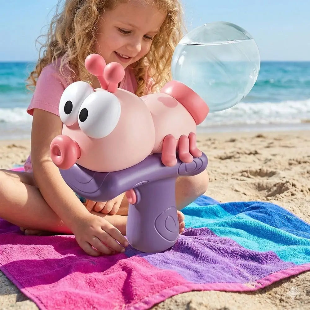 A young girl is holding a pink ant-shaped water blaster toy on a purple launcher on a sandy beach.