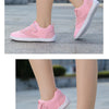 Pink kids barefoot training sneakers shown from the side and top view on a gray outdoor surface.