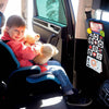 Un jeune enfant assis dans un siège auto regardant la caméra et tenant un jouet doux.