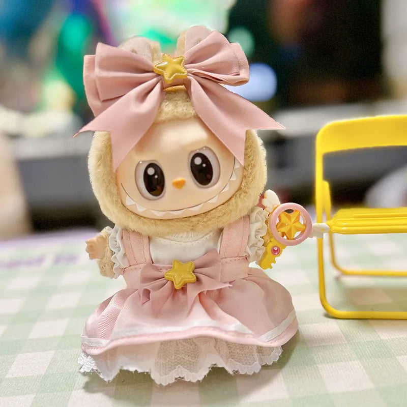 A cute doll outfit featuring pink tulle and a bow with a gold star detail.