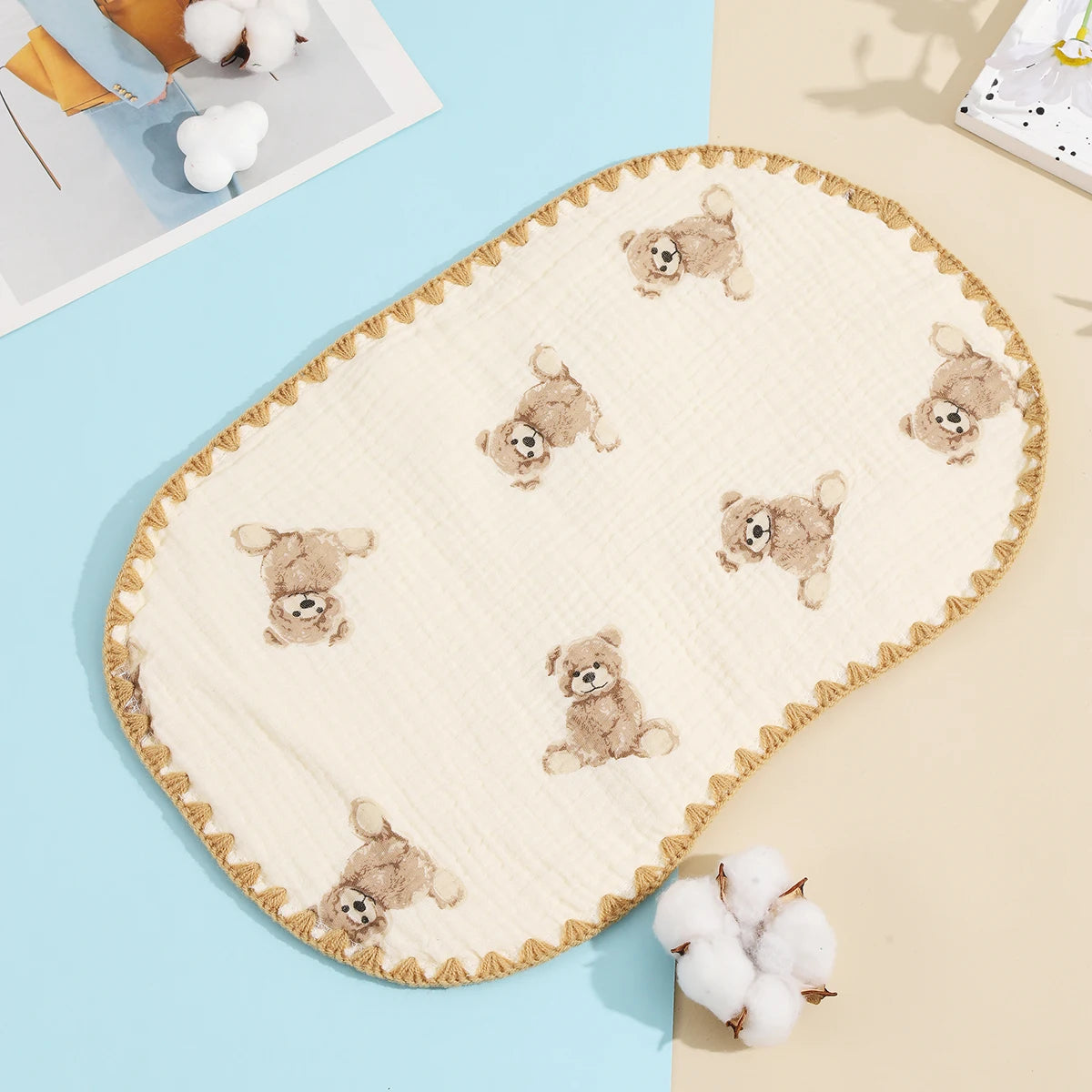 A cream-colored, embroidered flat pillow with a scalloped edge featuring small teddy bear appliqués on a light blue backgroun