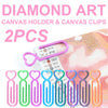 Two heart-shaped canvas clips in various colors pink green blue and orange are shown next to a roll of diamond art canvas.