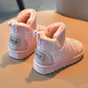 A pair of pink fur-lined winter snow boots with a white sole resting on a light surface.