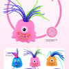 A pink rubber monster stress relief toy with purple and green hair, shown alongside three expressions in six colors.