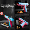 A pink and blue automatic shell-ejecting fidget pistol toy is shown with various ammunition and a target in a dark setting.