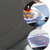A hand is decorating a cake with colorful frosting using a rotating turntable and tools from a cake decorating kit.