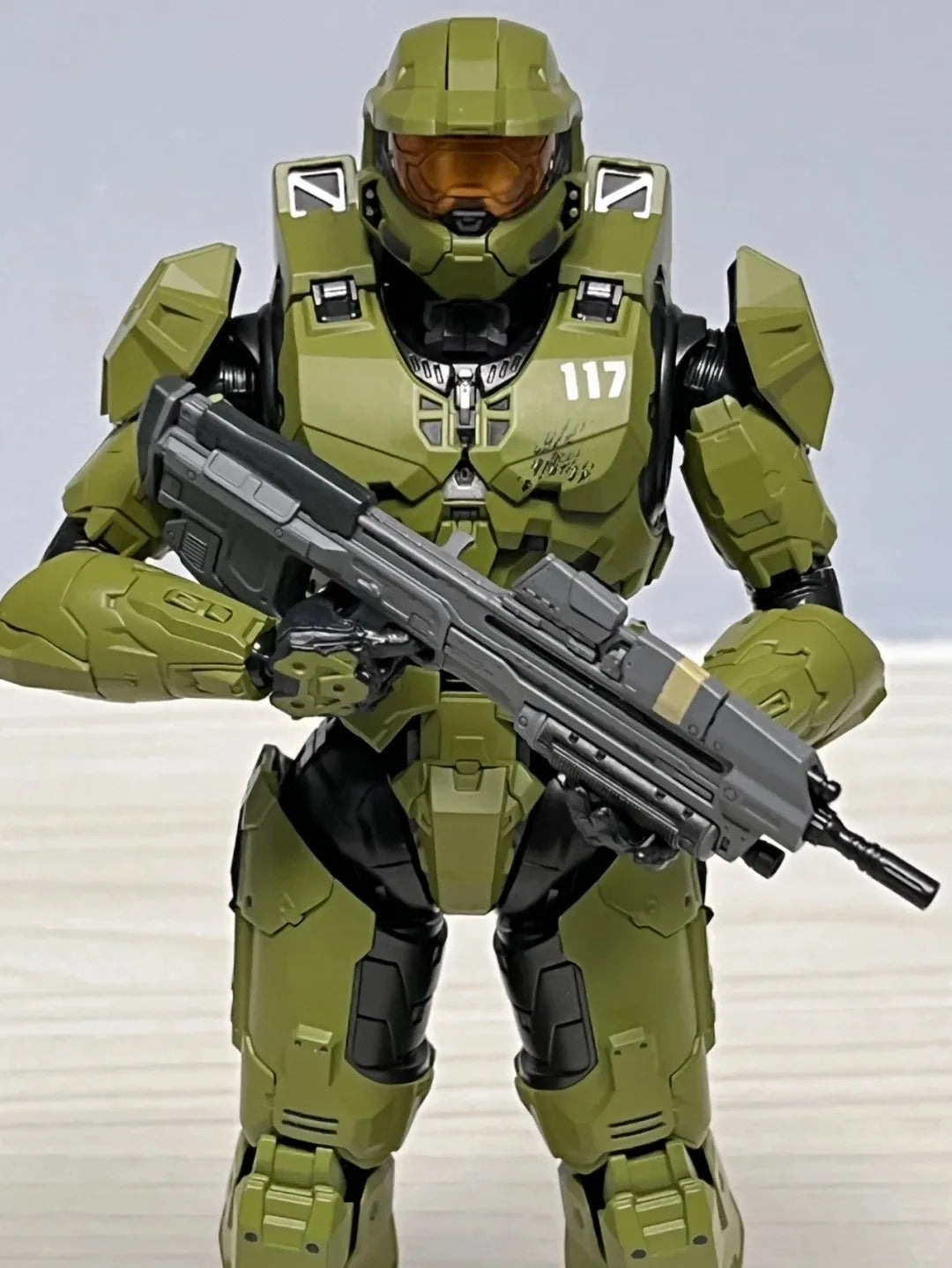 A 1/12 scale Master Chief action figure in olive green armor and helmet holding an assault rifle.