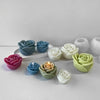 A collection of pastel silicone molds shaped like rose flowers in various shades of blue, green, and pink.