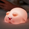 A pink silicone rabbit night light with a touch sensor resting on a surface.