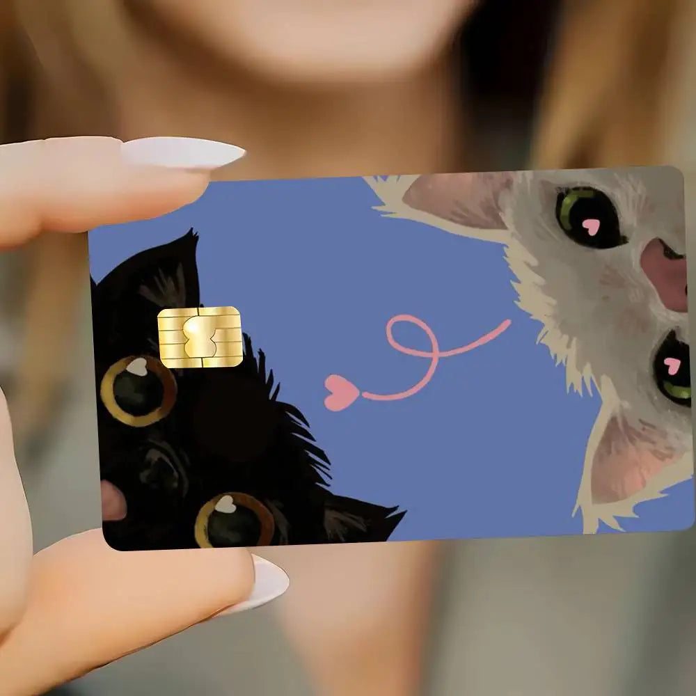A hand holds a card sticker featuring a black cat and a white wolf face with pink lines.