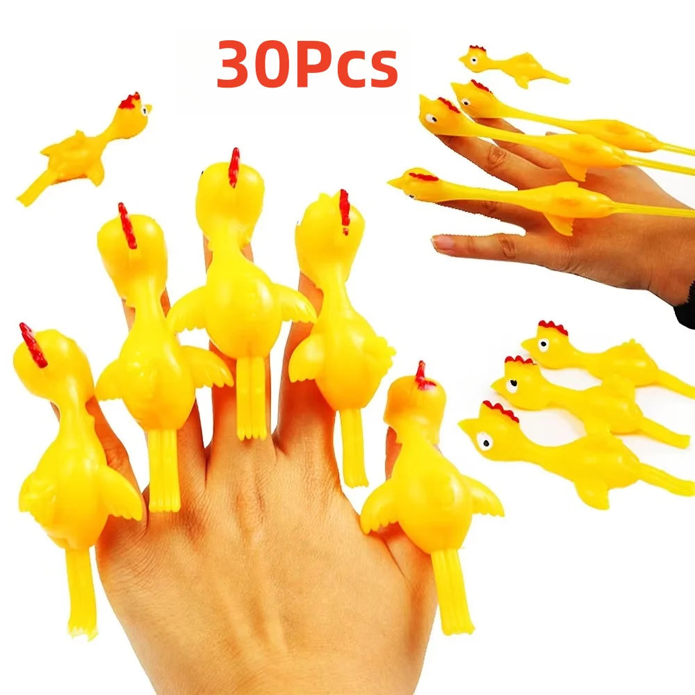 A hand is holding and launching yellow catapult chicken flying toys onto a white background.