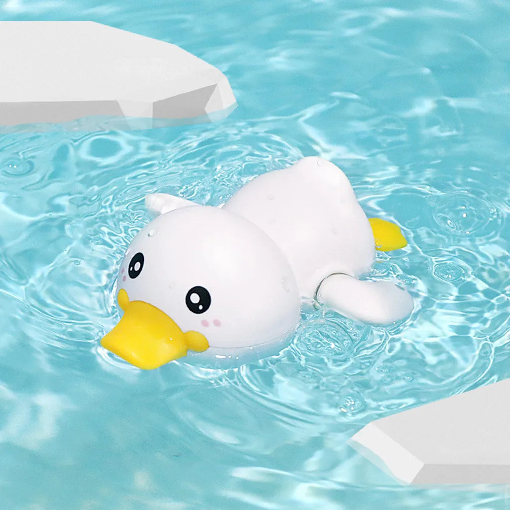 A white duck bath toy floating in clear blue water surrounded by white blocks.