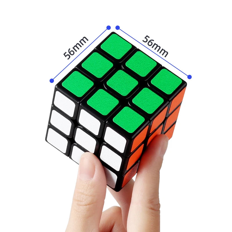 A hand holds a green and black magic cube puzzle with orange accents, showing its grid structure.