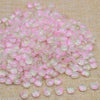 A pile of pink and clear glass beads shaped like tulip flowers.