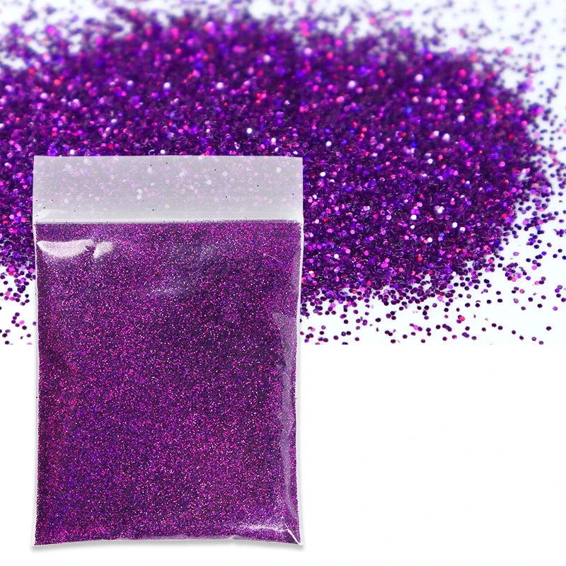 A small package of vibrant purple holographic glitter powder scattered across a white background.