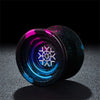 A close-up view of a professional metal yo-yo with iridescent blue and purple finishes, resting on a dark surface.
