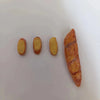 Three miniature baguettes of varying sizes displayed on a white surface.