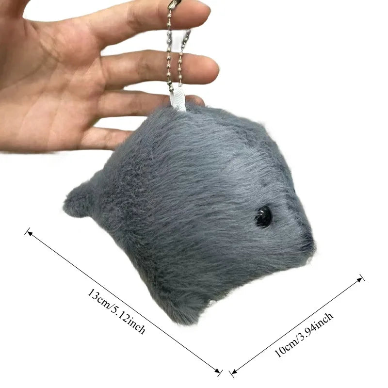 Adorable grey seal plush keychain being held in a hand
