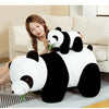 A white and black bamboo panda plush stuffed animal sitting on a sofa.