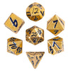A set of ten gold-colored metal dice, including a d6, d8, d10, d12, d20, and d100, displayed in a box.