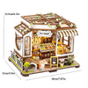 A wooden miniature dollhouse kit featuring a pet shop facade with furniture and warm lighting.