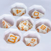 Seven white cheese-shaped polyhedral dice arranged in a hexagonal pattern on a white background.