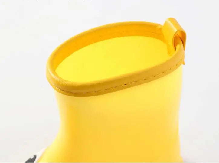 A bright yellow kids rain boot with a ribbed cuff and smooth body.