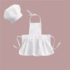 White kids chef apron and hat set for pretend play displayed on a pink background