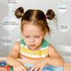 A young child is interacting with an interactive quiet book featuring animal stickers and shapes for cognitive development.