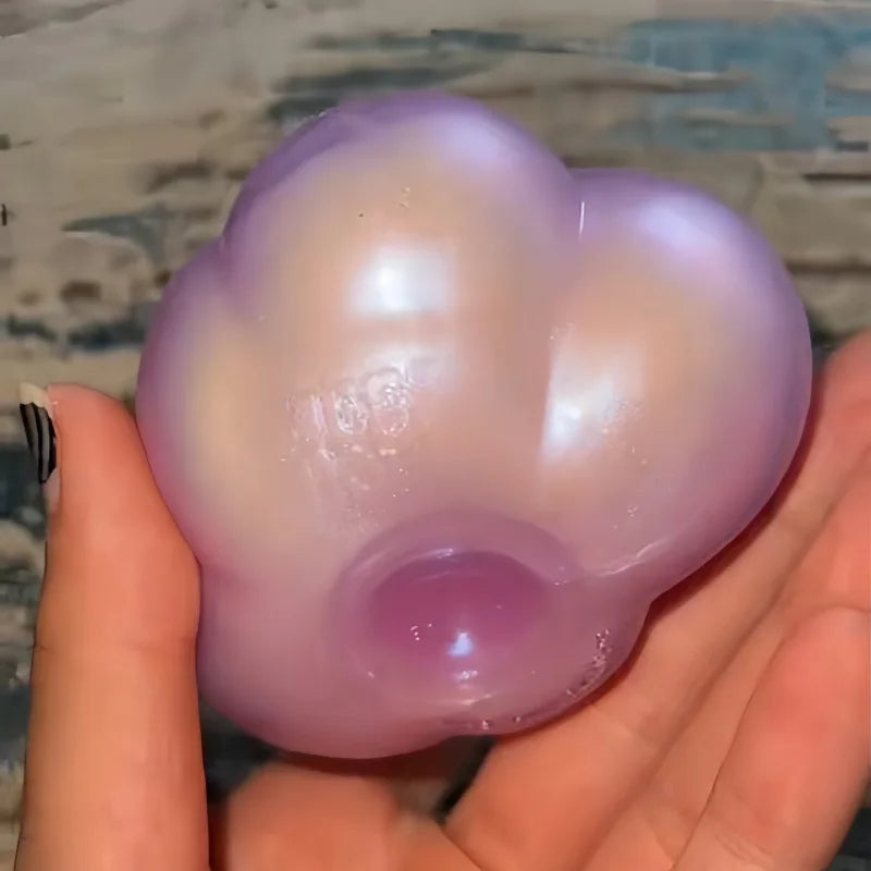 A translucent purple squishy cube is held in a hand, showing its soft, rounded shape.