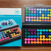 A box of Pyramid Bead Logic Puzzle with 120 challenges for adults, showing various colored plastic beads.