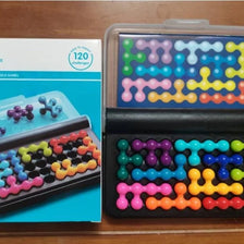 A box of Pyramid Bead Logic Puzzle with 120 challenges for adults, showing various colored plastic beads.