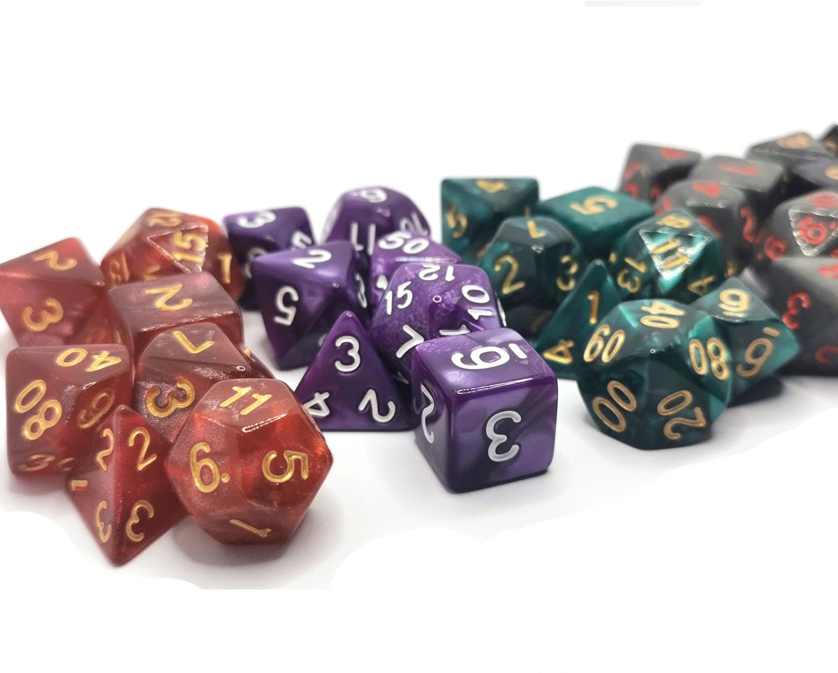 A collection of seven polyhedral dice in various colors and sizes laid out on a white surface.