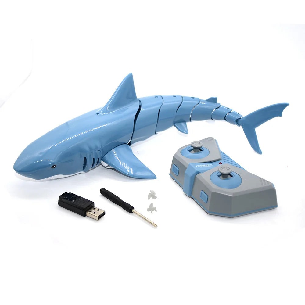 A blue shark toy remote control with light and water spray alongside its battery and accessory parts.