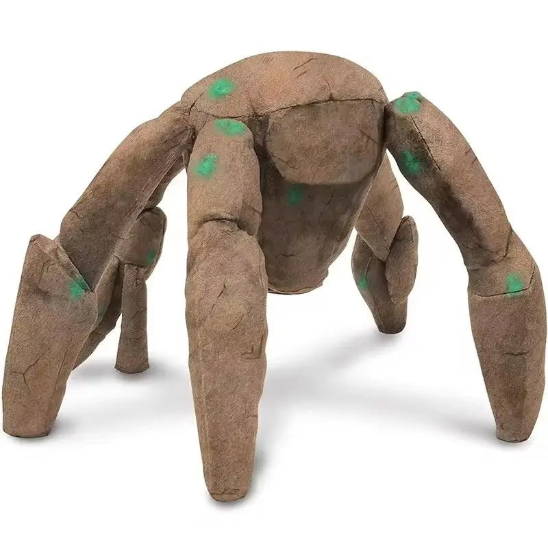 A brown soft plush toy resembling an alien hand with green accents.