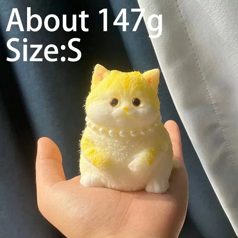 A small yellow cat shaped squishy stress relief toy is held in a person's hand.