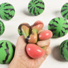 A hand holds a green and black patterned fruit squishy stress relief fidget toy.