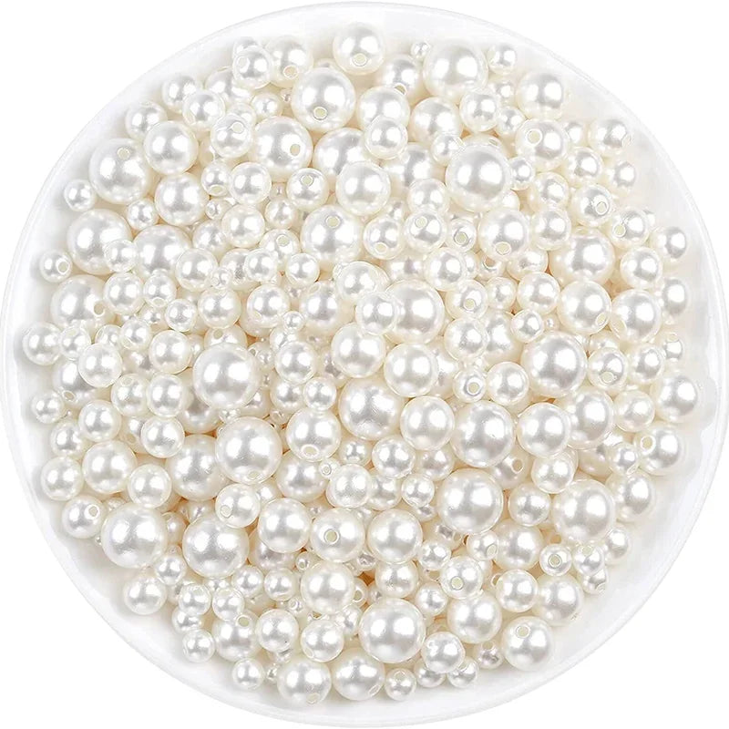 A pile of small, round ivory pearl beads for DIY jewelry making.